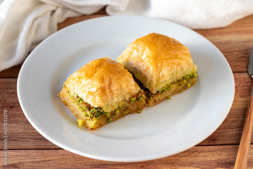 Pistachio baklava on wooden background. Traditional Turkish cuisine delicacies. close up Pistachio baklava on wooden background. Traditional Turkish cuisine delicacies. close up