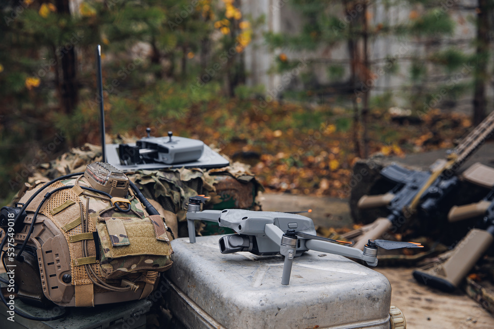 Army drone for reconnaissance purposes, aiming artillery and revealing enemy positions. Concept use modern Quadcopter air robot in military tasks