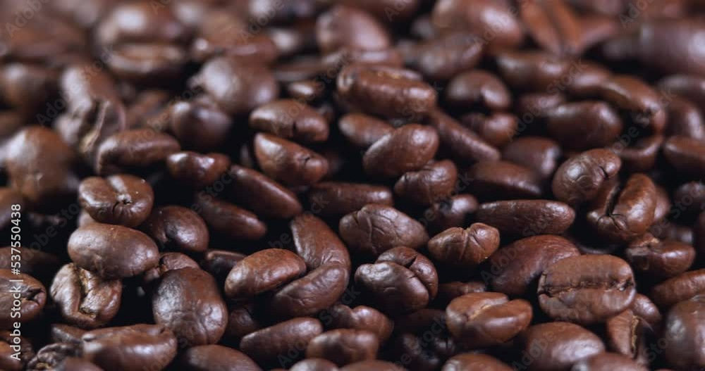 Roasted coffee beans dolly shot. Aromatic coffee beans move slowly. Slide slow motion close-up of whole roasted coffee beans. Roasted coffee beans dolly shot. Aromatic coffee beans move slowly. Slide slow motion close-up of whole roasted coffee beans.