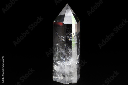 Real clear crystal quartz point focused macro isolated on black surface  photo