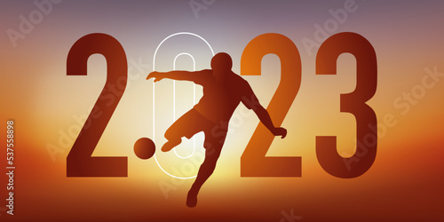 Concept du sport sur le thème du football pour une carte de vœux 2023, montrant un footballeur qui frappe le ballon du pied pour marquer un but.