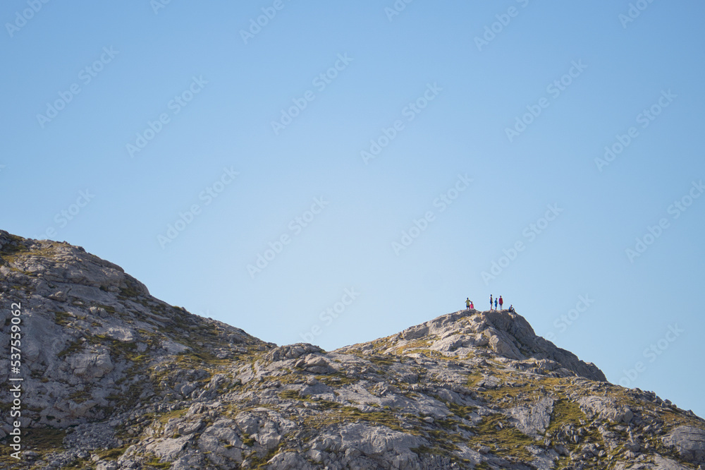 Personas celebrando la llegada a la cima de una montaña Personas celebrando la llegada a la cima de una montaña