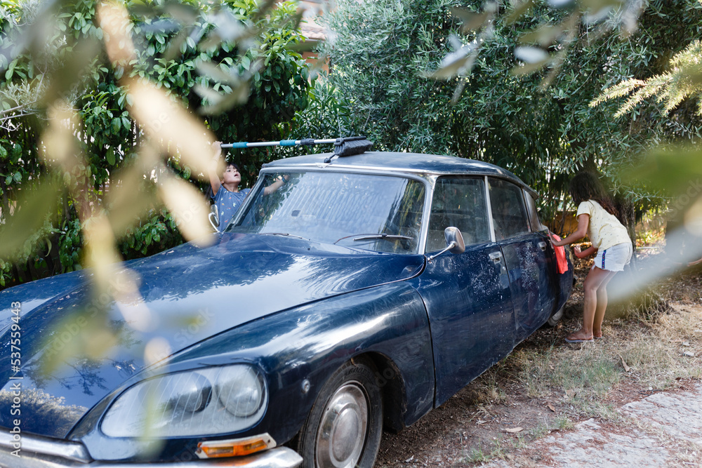 two girls washing family car in the garden two girls washing family car in the garden