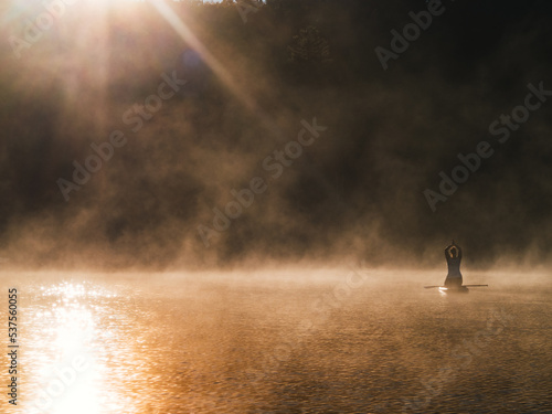 Woman paddling on sup board on Sunrise