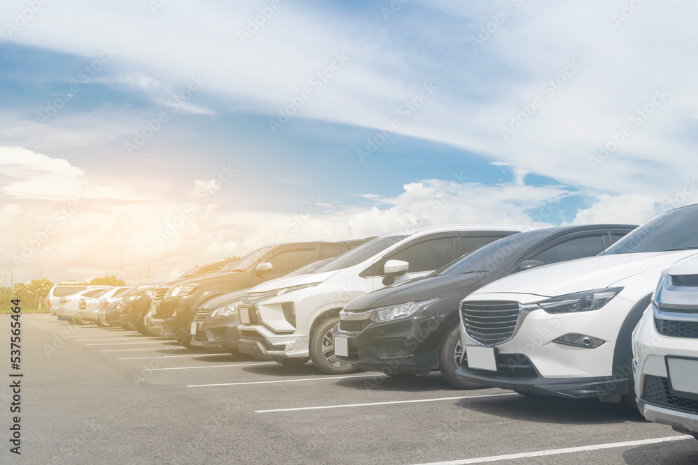 Car parked in large asphalt parking lot with beautiful cloud and blue sky background. Outdoor parking lot  travel transportation technology with nature concept