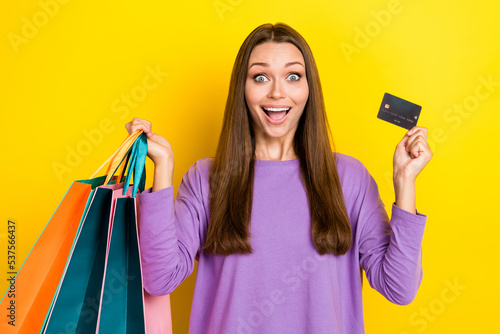 Photo of shocked surprised cheerful lady rejoice bank plastic card comfort fast payment online shopping isolated on yellow color background