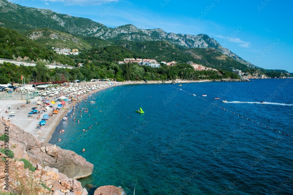 Beautiful landscape of Kamenovo pebble beach located in bay surrounded by green mountains near village of Rafailovici. Budva Riviera. Montenegro.
