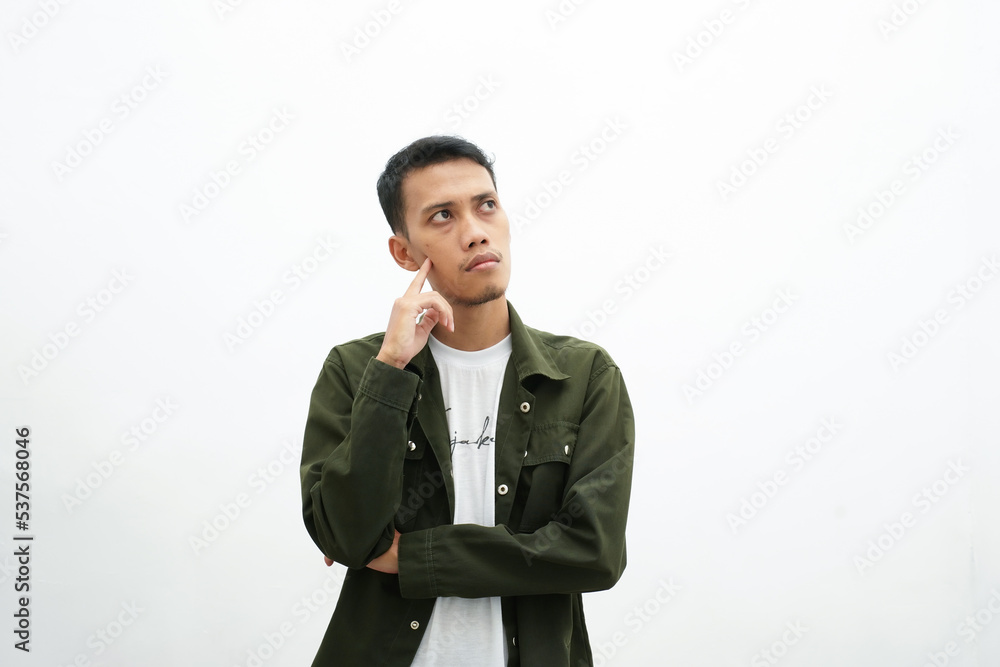 Asian man wearing casual green shirt is thinking. isolated white background Asian man wearing casual green shirt is thinking. isolated white background