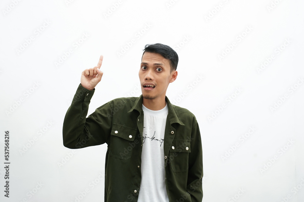 Asian man wearing casual green shirt pointing to an empty space for advertising space. isolated white background Asian man wearing casual green shirt pointing to an empty space for advertising space. isolated white background