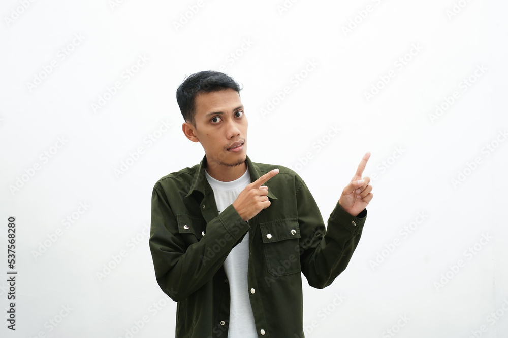 Asian man wearing casual green shirt pointing to an empty space for advertising space. isolated white background Asian man wearing casual green shirt pointing to an empty space for advertising space. isolated white background