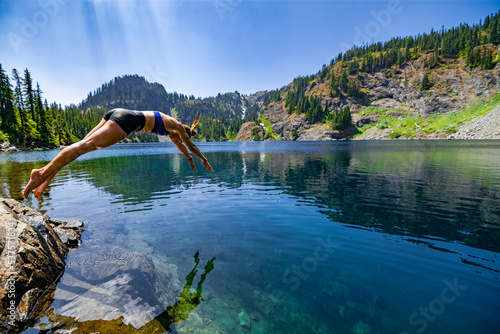 Canvastavla Adventurous athletic female hiker diving into an alpine lake in the Pacific Northwest