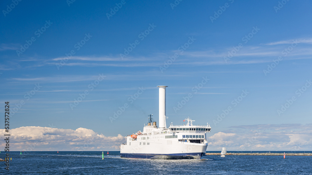 Schiff bzw. Fähre mit alternativem Segel, einem Flettner-Rotor, in der Hafeneinfahrt von Rostock Warnemünde
