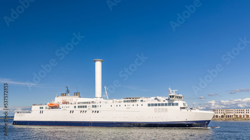Schiff bzw. Fähre mit Segel, einem Flettner-Rotor, in der Hafeneinfahrt von Rostock Warnemünde