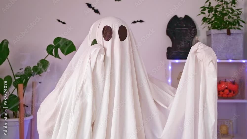 The Halloween Ghost uses a mobile phone for calls, congratulations, intimidation. The ghost makes an order from a smartphone on Halloween. Funny Halloween concept. Neon light. The Halloween Ghost uses a mobile phone for calls, congratulations, intimidation. The ghost makes an order from a smartphone on Halloween. Funny Halloween concept. Neon light.