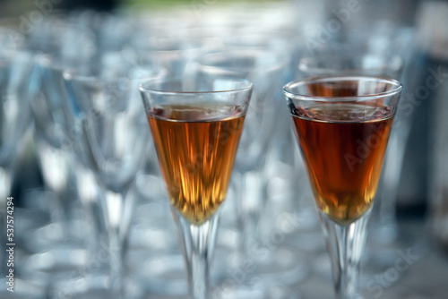 Golden colored alcoholic short drinks in shot glasses. Illustration photo of celebration or fun lifestyle.
