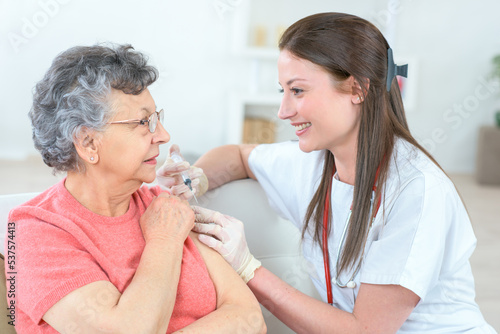 nurse giving injection to senior woman in the arm