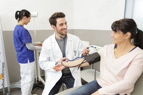doctor measuring blood pressure of woman