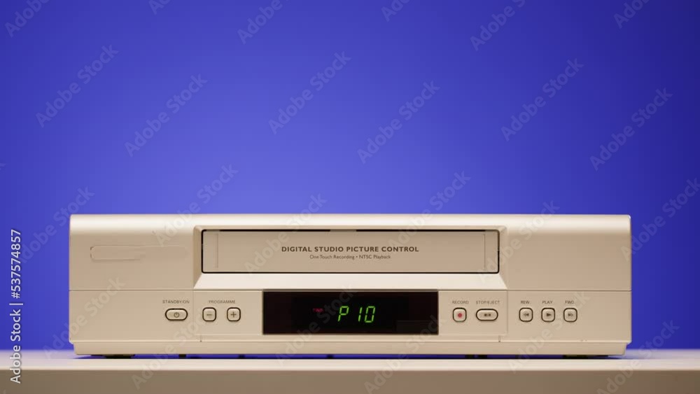 Old video recorder close-up, VHS. Retro player, vintage video cassette broadcasting on blue background, audio tape. Old video recorder close-up, VHS. Retro player, vintage video cassette broadcasting on blue background, audio tape.