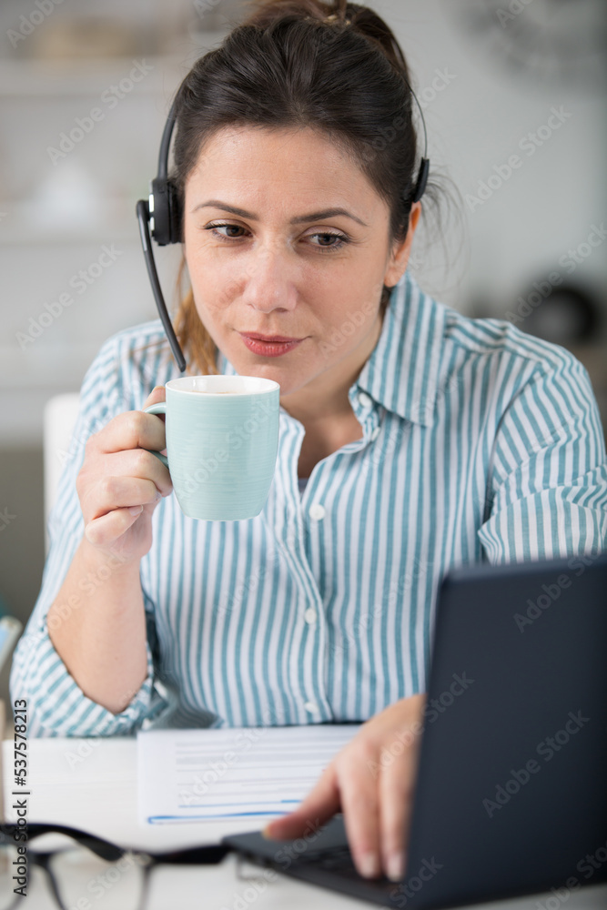 beautiful woman holding coffee cup while working beautiful woman holding coffee cup while working