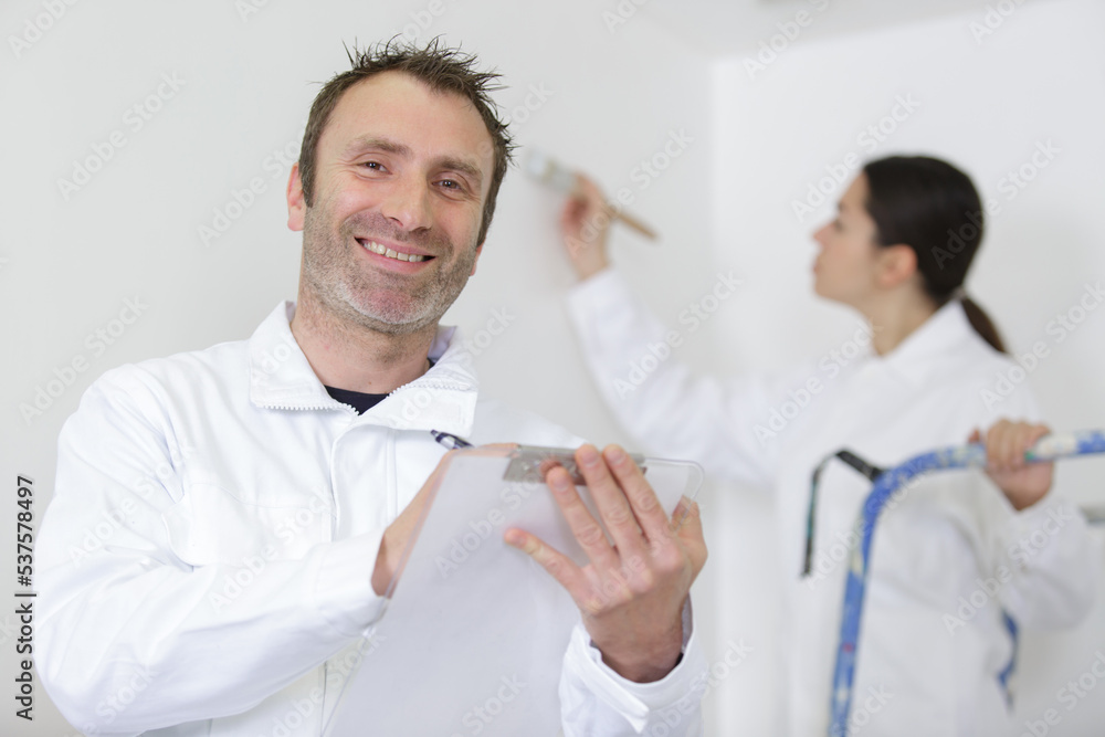 Obraz premium happy painter worker on clipboard