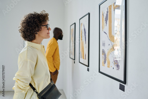 Quadro su tela Young people watching at paintings hanging on the wall during exhibition at gall