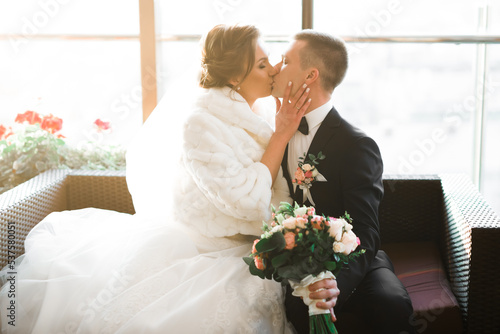 Beautiful bride and groom embracing and kissing on their wedding day
