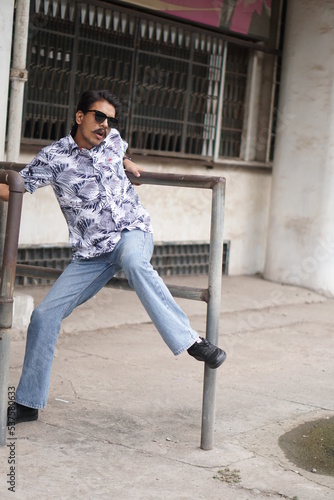 mans wearing white shirt posing infront of old vintage building