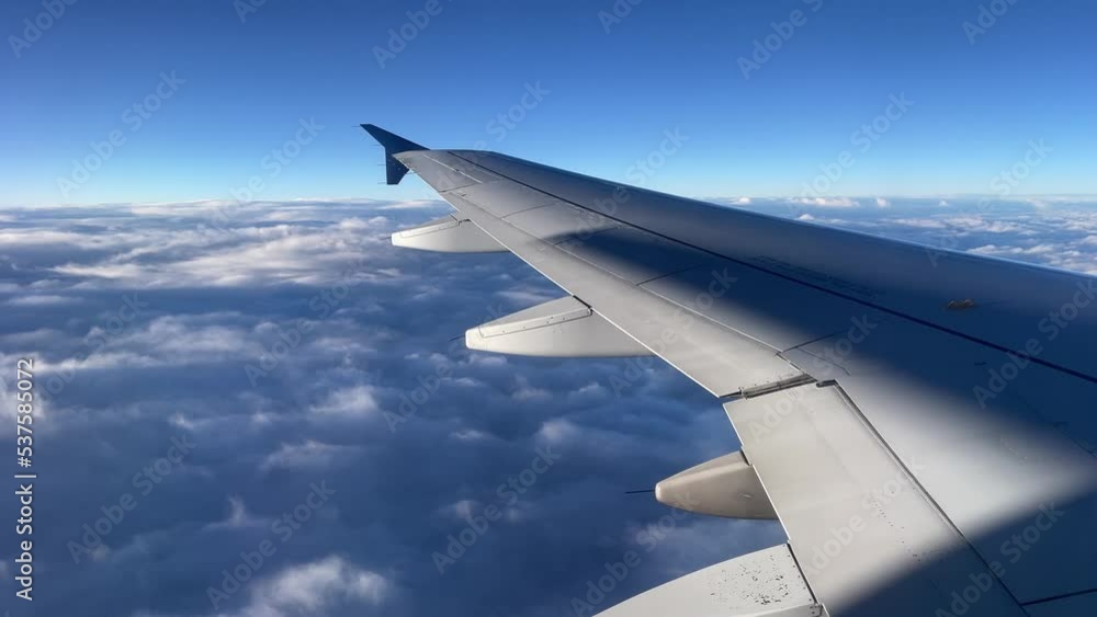 Airplane wing flying over clouds with sunlight just touching the tops of the clouds. Airplane wing flying over clouds with sunlight just touching the tops of the clouds.