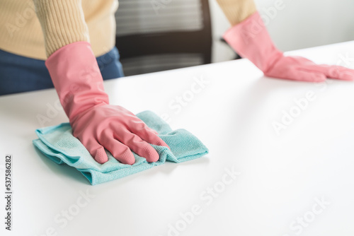 happy Female housekeeper service worker wiping table surface by cleaner product to clean dust.