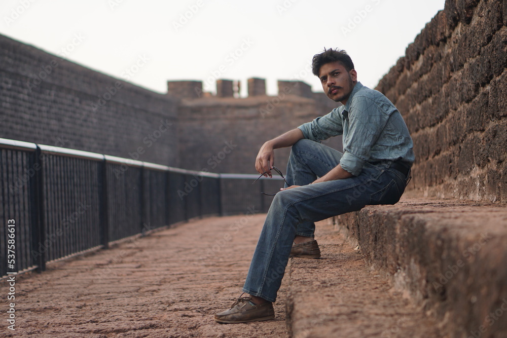 man sitting on old building roadside man sitting on old building roadside