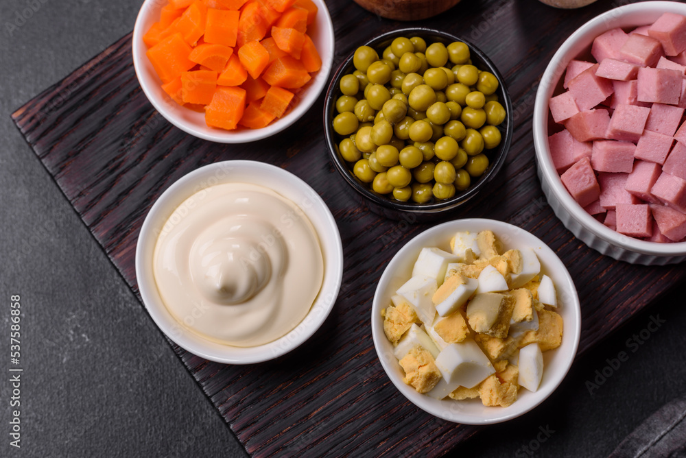 Delicious fresh Olivier salad with sausage, egg, cucumber, green peas, carrots and mayonnaise Delicious fresh Olivier salad with sausage, egg, cucumber, green peas, carrots and mayonnaise