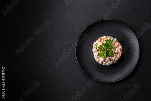 Delicious fresh Olivier salad with sausage, egg, cucumber, green peas, carrots and mayonnaise