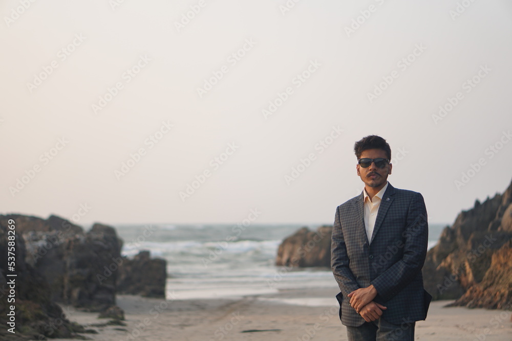 man wearing sui posing near beach