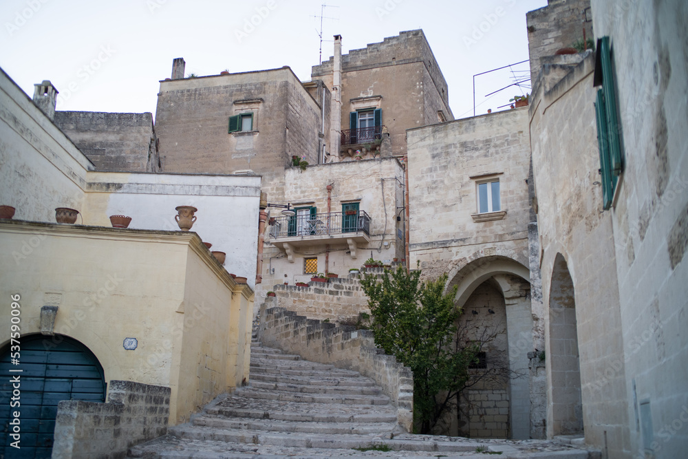 old stone houses and churches on the ravine slopes in the historic center of the old town of Matera. Narrow cobbled streets and cascading buildings with rocks and tightly built-up streets old stone houses and churches on the ravine slopes in the historic center of the old town of Matera. Narrow cobbled streets and cascading buildings with rocks and tightly built-up streets
