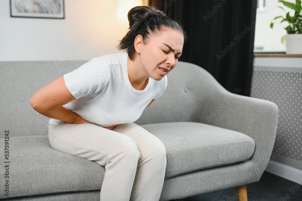 Young woman suffering from menstrual cramps at home. Gynecology Young woman suffering from menstrual cramps at home. Gynecology