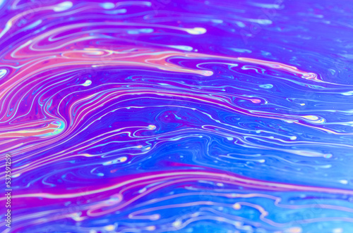 Macro of colorful fluid surface with iridescent colors, abstract patterns and shapes, futuristic rainbow colored space art background