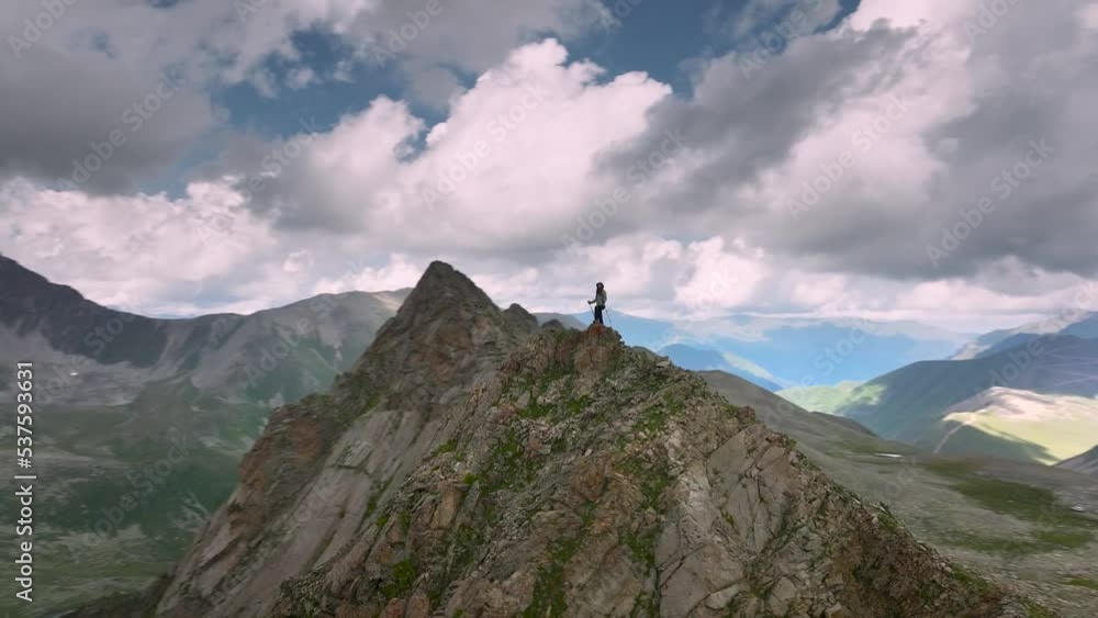 Air view. Fantasy adventure composite with a girl on top of a rocky cliff with a beautiful Canadian mountain natural landscape in the background during sunset or sunrise. 2.5D zoom Air view. Fantasy adventure composite with a girl on top of a rocky cliff with a beautiful Canadian mountain natural landscape in the background during sunset or sunrise. 2.5D zoom