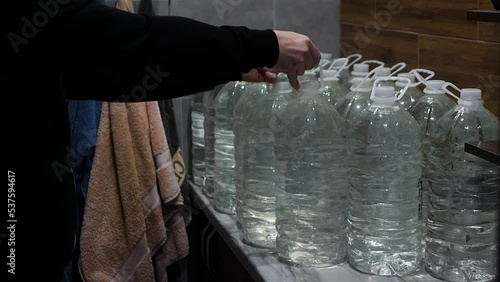 Stocks of water during the war in Ukraine. A person stocks up on water in the apartment. Lots of plastic bottles filled with drinking water during the war