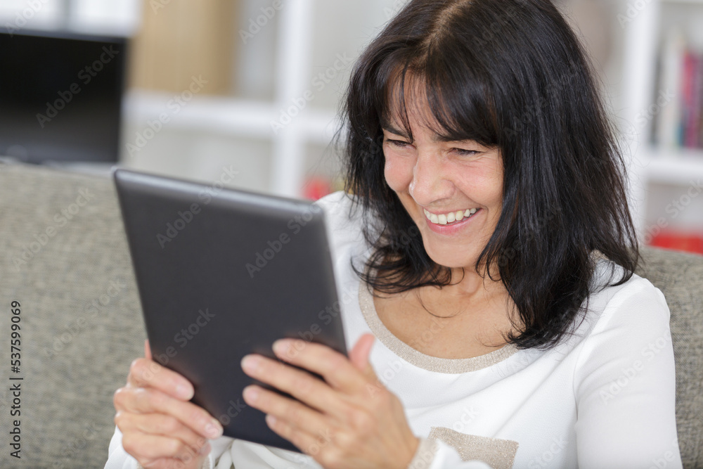 happy mature woman using her tablet happy mature woman using her tablet