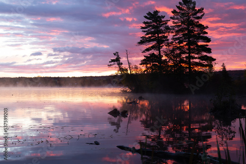 Mist rising from Lovering Lake during a dramatic fall dawn, Magog, Eastern Townships, Quebec, Canada