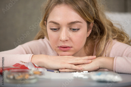 young woman looking sadly at her smoking paraphernalia