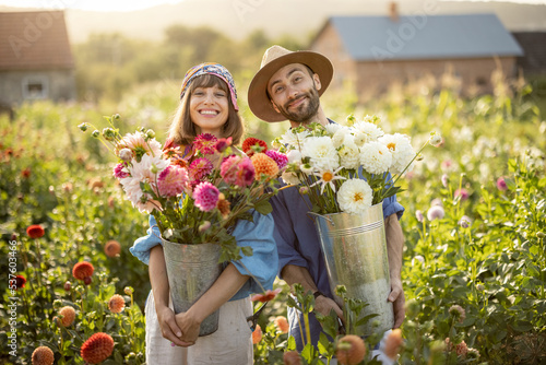 Obraz na płótnie Portrait of cheerful man and woman stand as farmers with buckets full of freshly