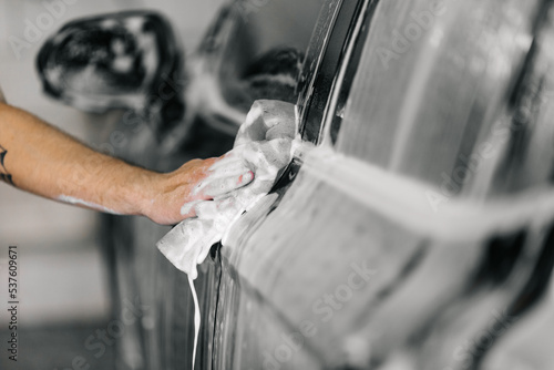 Man washing his car in a self-service car wash station.Car wash self-service.