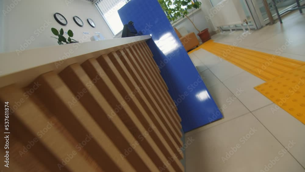 Yellow tactile paving near reception in hallway of medical center ...