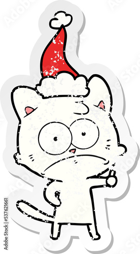 hand drawn distressed sticker cartoon of a nervous cat wearing santa hat