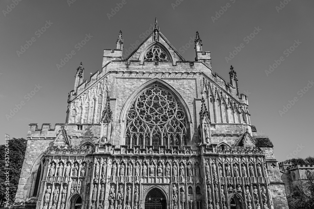 Exeter, Devon, England, UK: Facade of Exeter Cathedral; the Cathedral Church of Saint Peter in Exeter; the medieval gothic Cathedral of Exeter in black and white