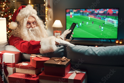 Fototapeta Naklejka Na Ścianę i Meble -  Happy Santa watching a soccer game