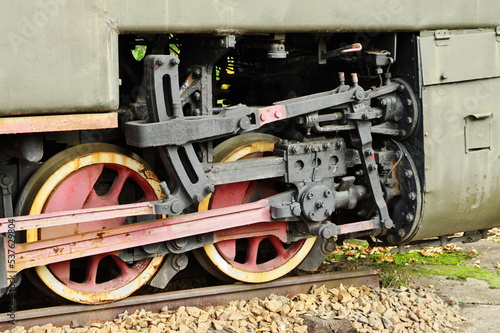 Historic railway. Old steam locomotive. A part of the suspension. Wheels and pistons are visible.