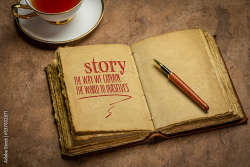 story - the way we explain the world to ourselves, handwriting in a retro journal with a cup of tea, storytelling and interpretation of reality concept