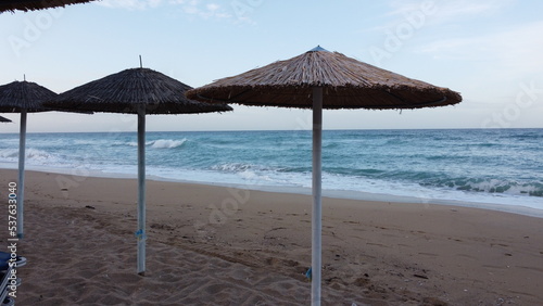 A beautiful sandy Mediterranean beach with rows of reed umbrellas